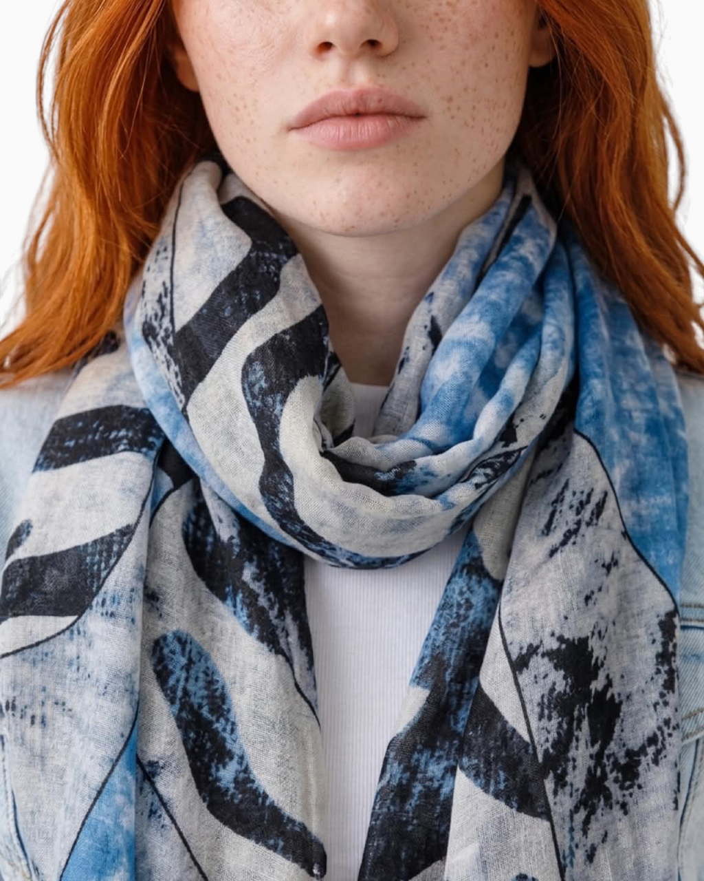 Thrift N Gift lightweight scarf with abstract blue, white, and charcoal print and frayed edges worn by a model