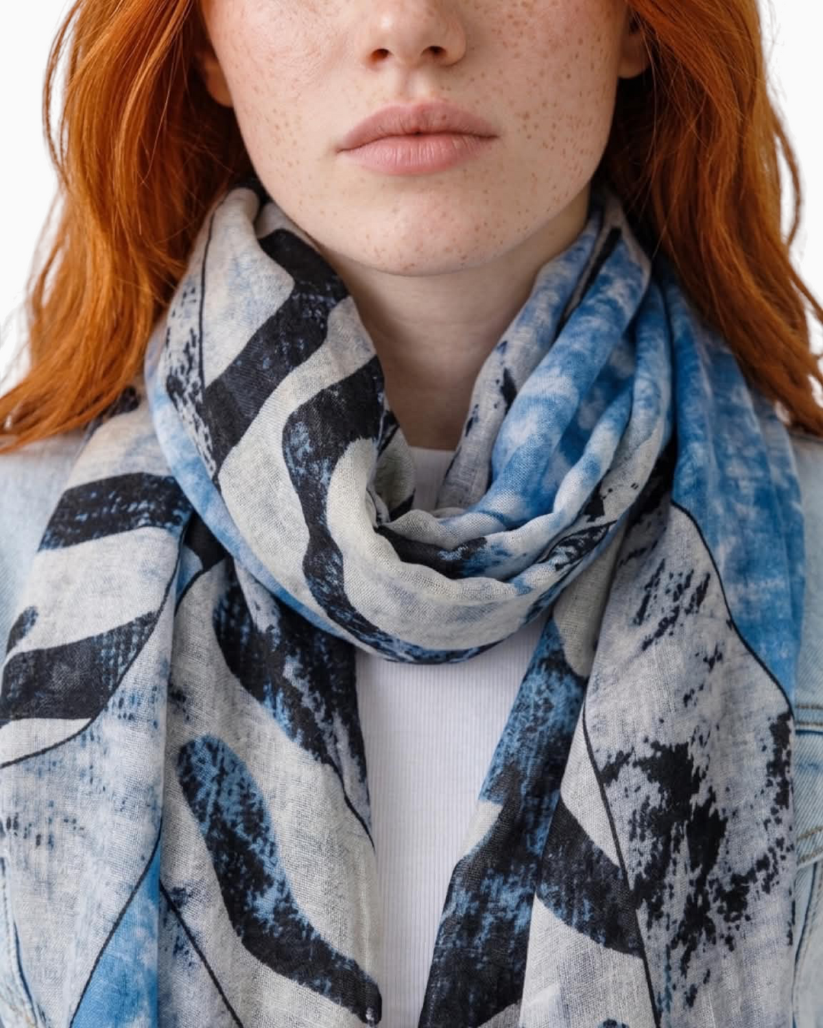 Thrift N Gift lightweight scarf with abstract blue, white, and charcoal print and frayed edges worn by a model