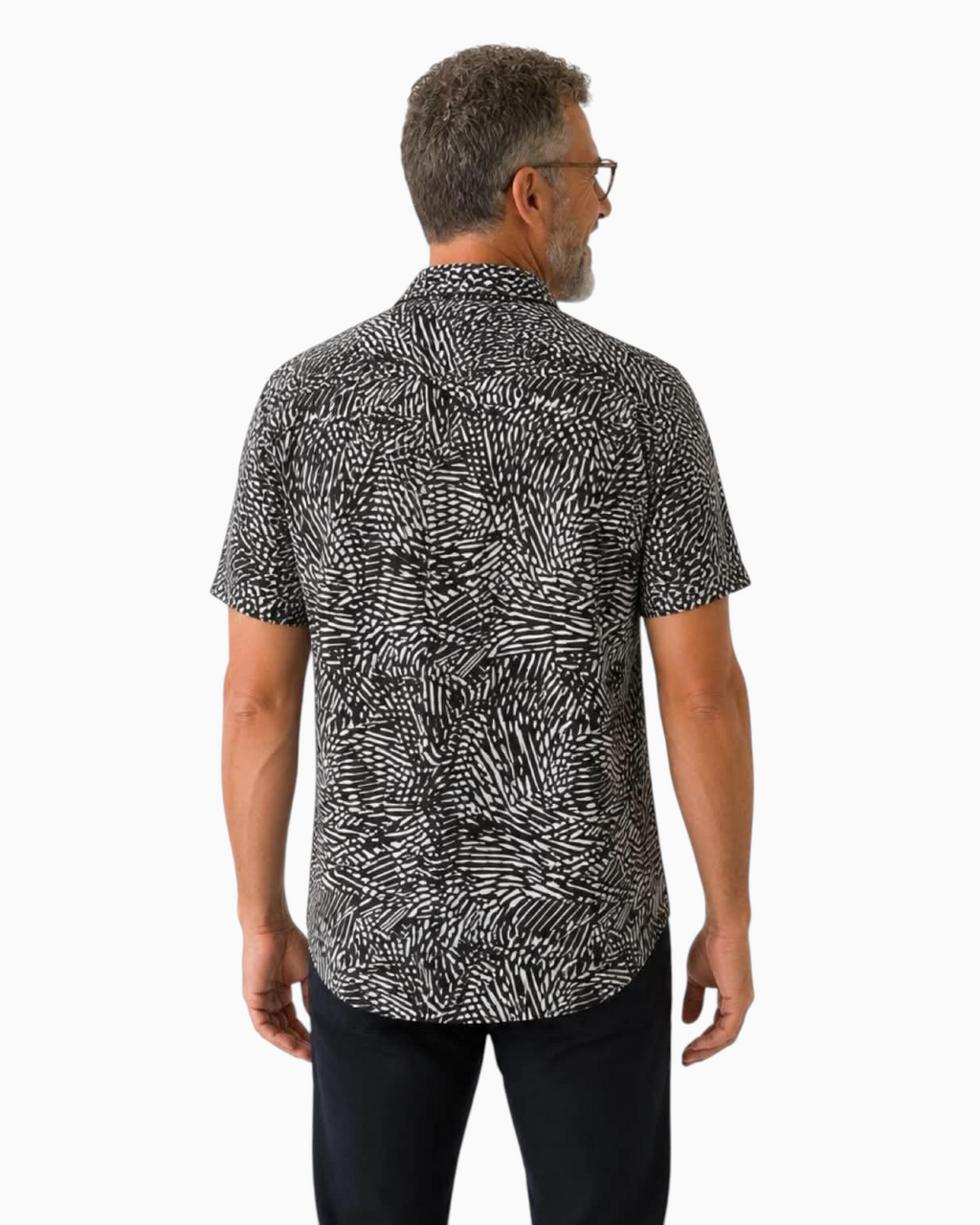 Back view of a man wearing a Thrift N Gift black and white abstract print short sleeve button down shirt
