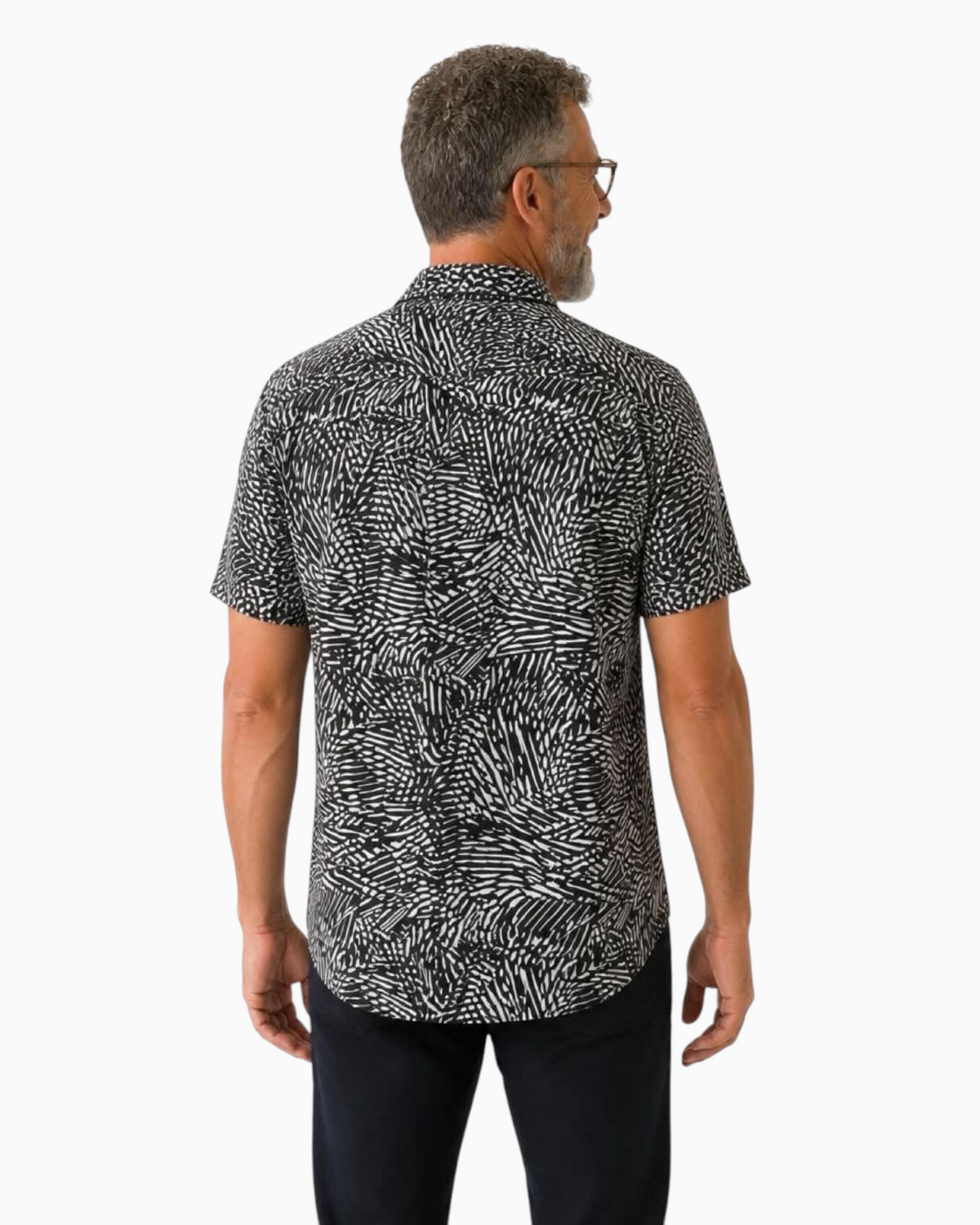 Back view of a man wearing a Thrift N Gift black and white abstract print short sleeve button down shirt