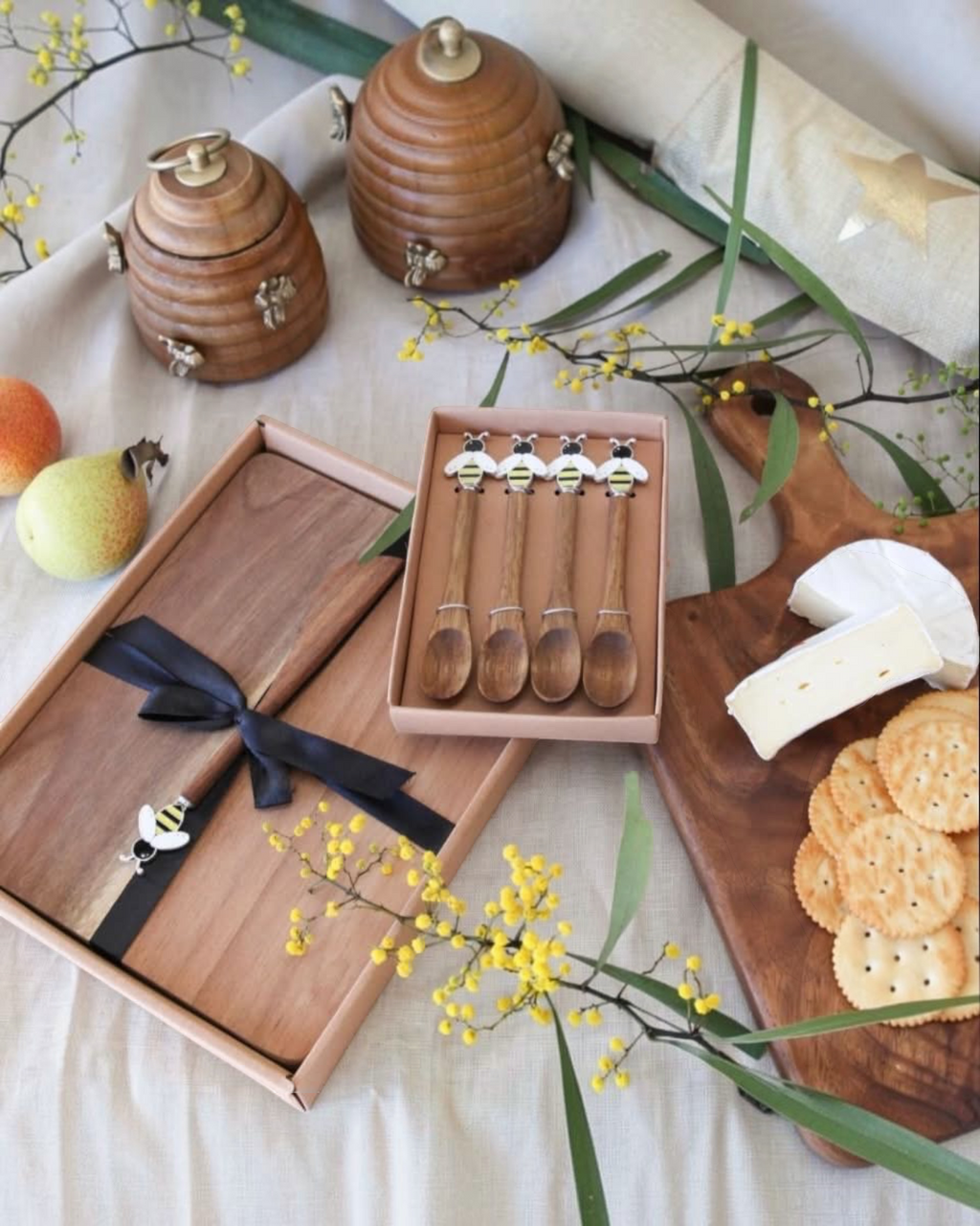 Thrift N Gift set of four acacia wooden spoons with decorative bee motifs in a gift box on a rustic table setting