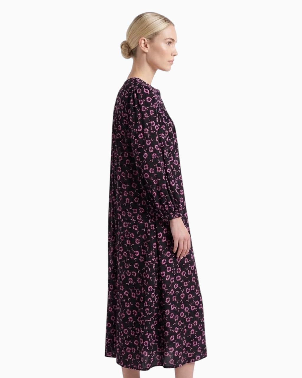Thrift N Gift black midi dress with pink floral print, long sleeves, and tiered skirt worn by a model, side view