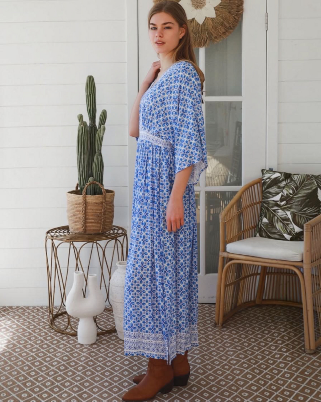 Thrift N Gift model wearing a blue and white geometric print bohemian maxi dress with lace trim and wide sleeves.
