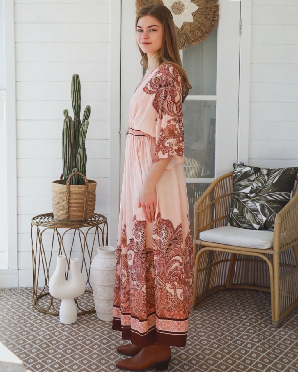 Thrift N Gift bohemian maxi dress in blush pink with terracotta paisley print, kimono sleeves, and brown ankle boots.
