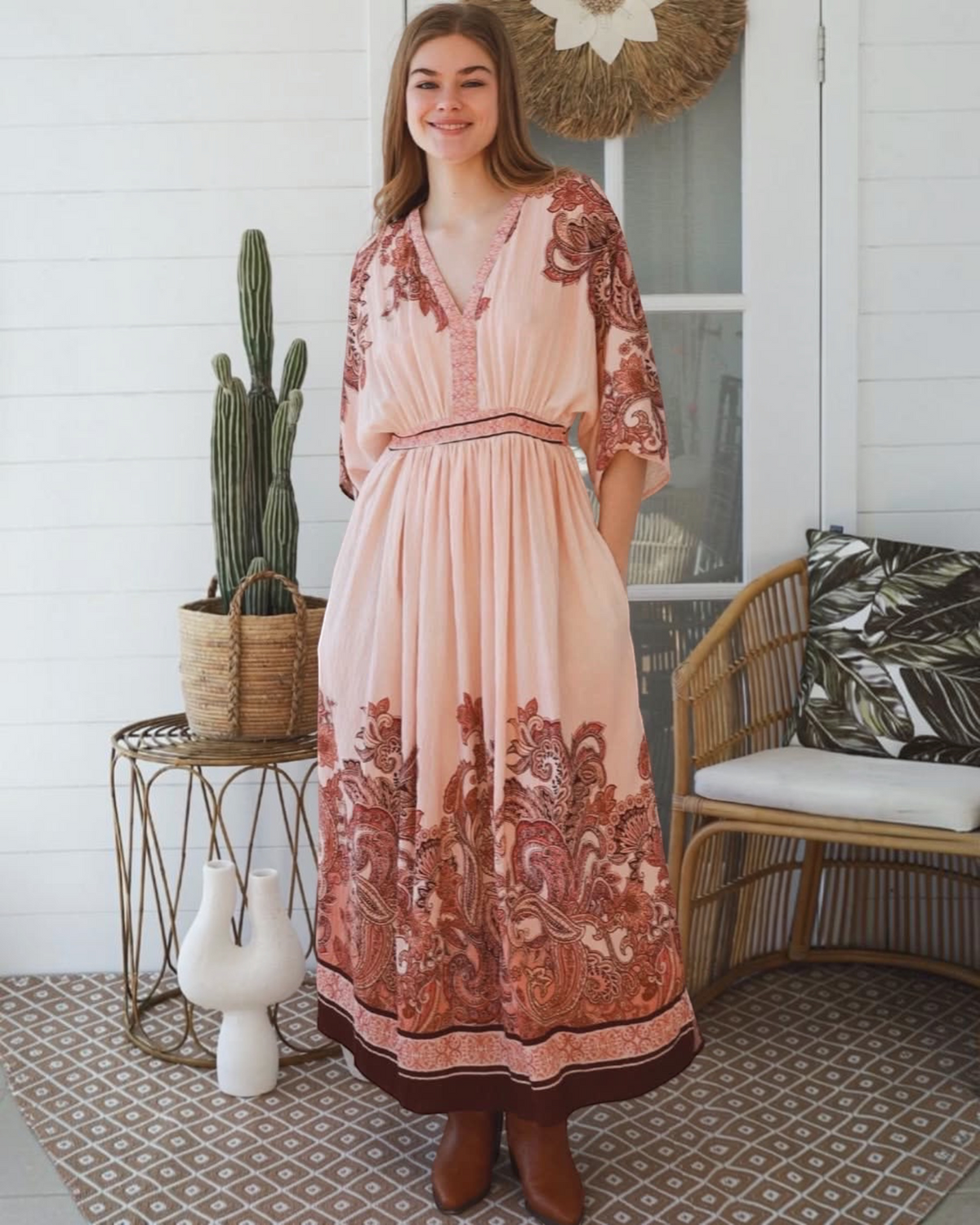 Thrift N Gift bohemian maxi dress in blush pink with terracotta paisley print, V-neck, and kimono sleeves on a model.
