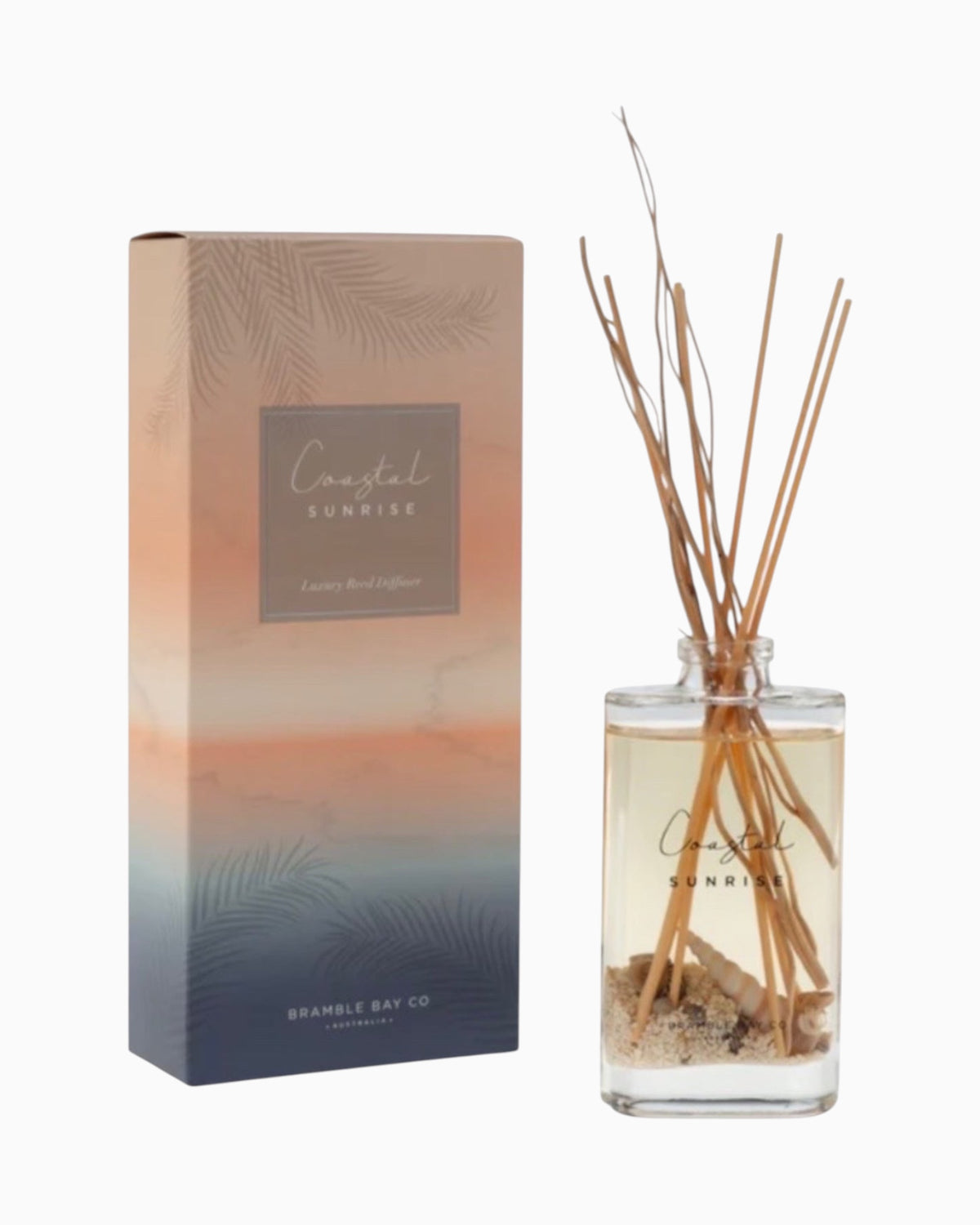 Thrift N Gift Bramble Bay Coastal Sunrise reed diffuser in a glass bottle with sand, seashells, and willow sticks.