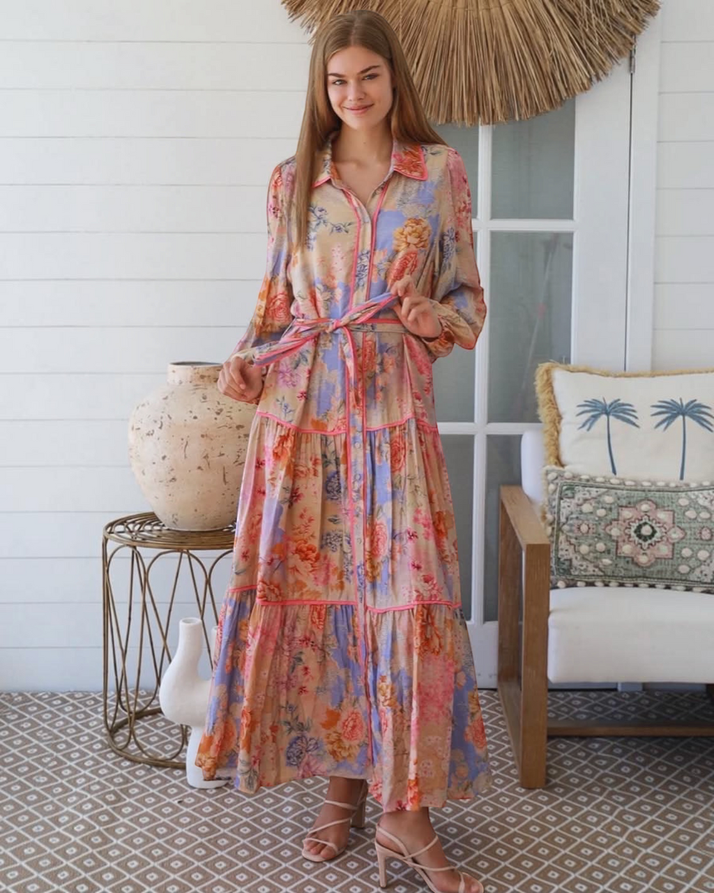 Thrift N Gift floral print button-down maxi dress with long sleeves, tiered skirt, and waist tie in warm pastel hues.