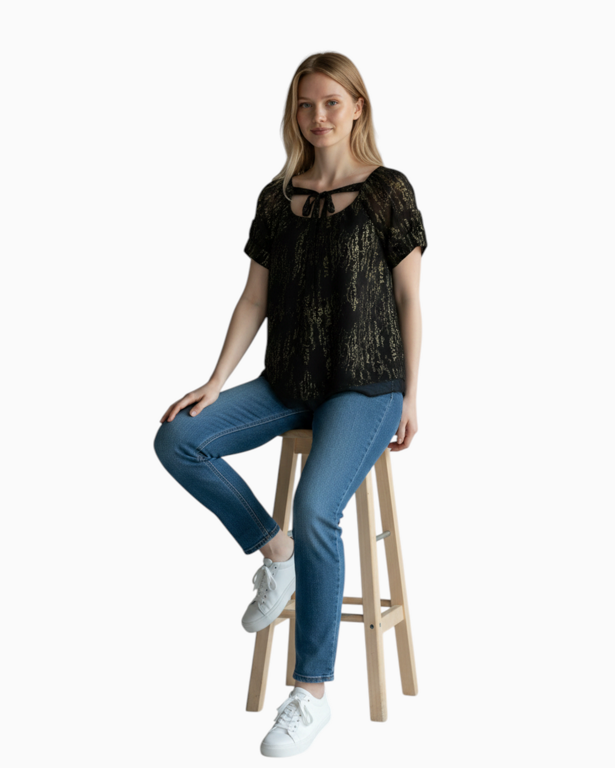 Thrift N Gift Gap black and gold sheer short sleeve blouse with tie-neck detail worn by a model on a wooden stool.