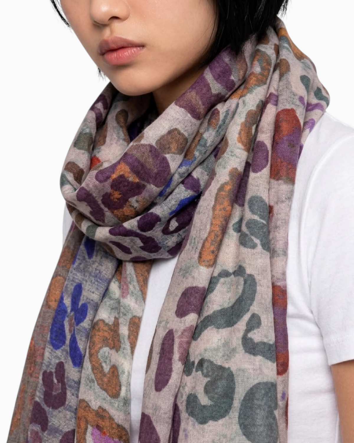 Thrift N Gift lightweight leopard print scarf with purple, blue, and earthy tones worn by a model over a white tee.