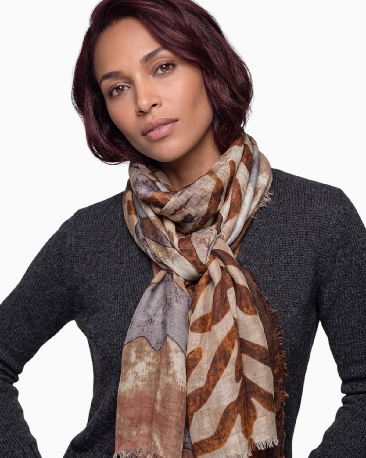 Thrift N Gift lightweight scarf with abstract earth-tone print and frayed edges worn by a woman in a grey sweater