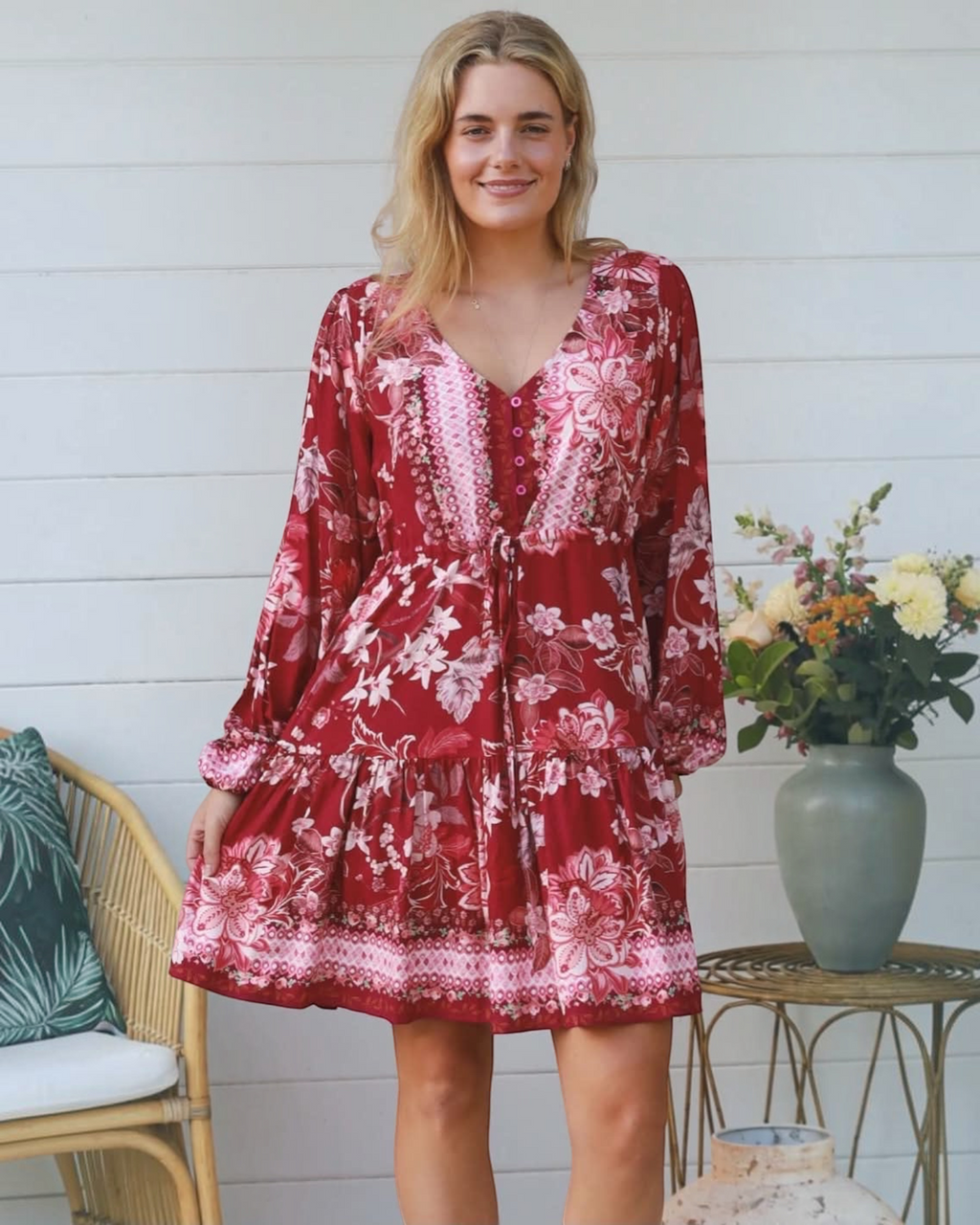 Thrift N Gift red floral print mini dress with long billowy sleeves, V-neck, and tiered skirt on a smiling model